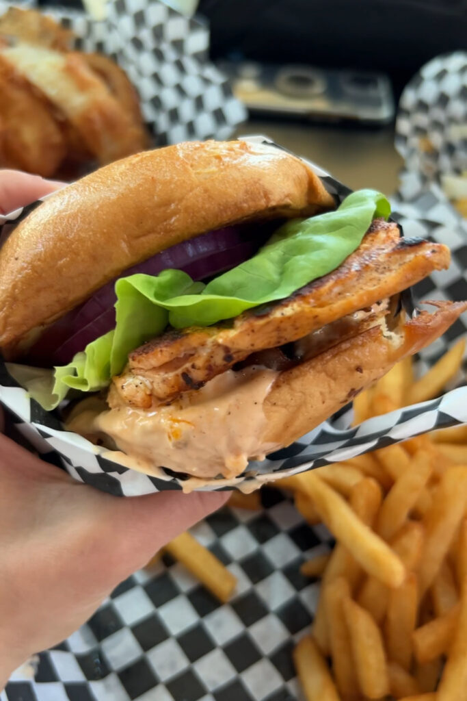 A Hand holding a Salmon BLT