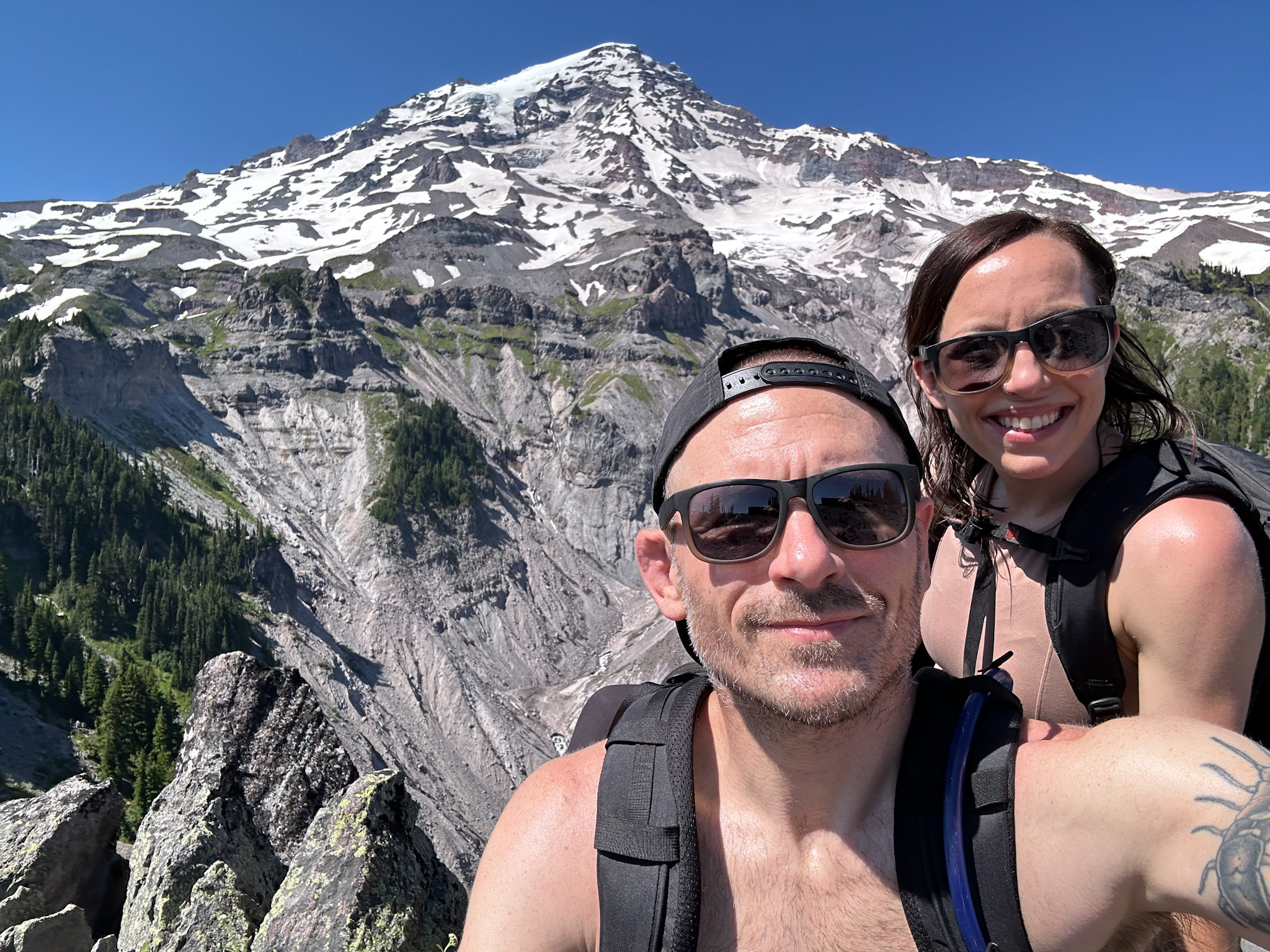 A man and woman taking a selfie in front of Mount Rainier